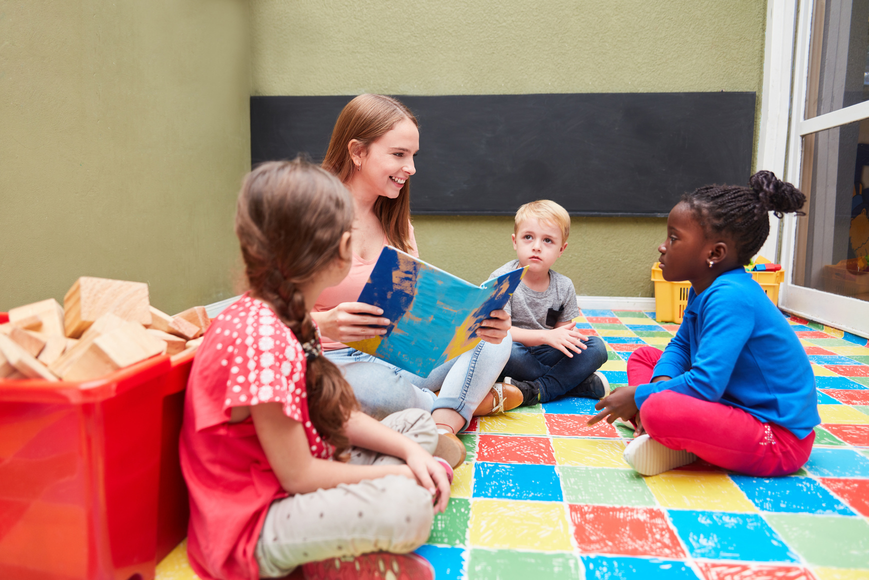 Teen Girl Reading a Story to Preschool Kids